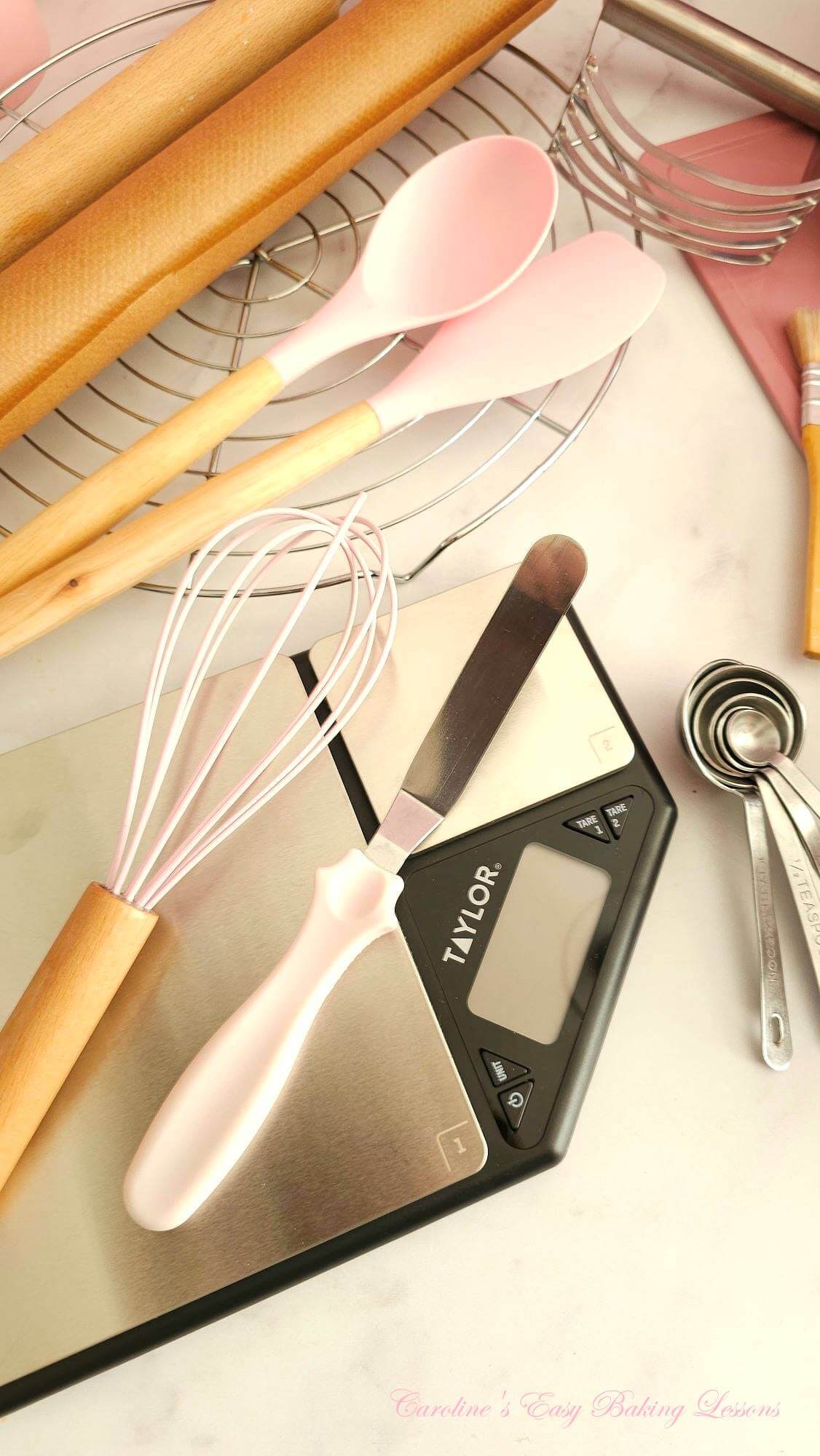 Photo of digital scales, whisk, paletteknife, spoons and rolling pin.