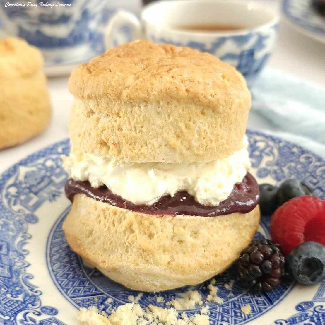 Extra extra close shot of a high, British scone, filled with cream & jam.