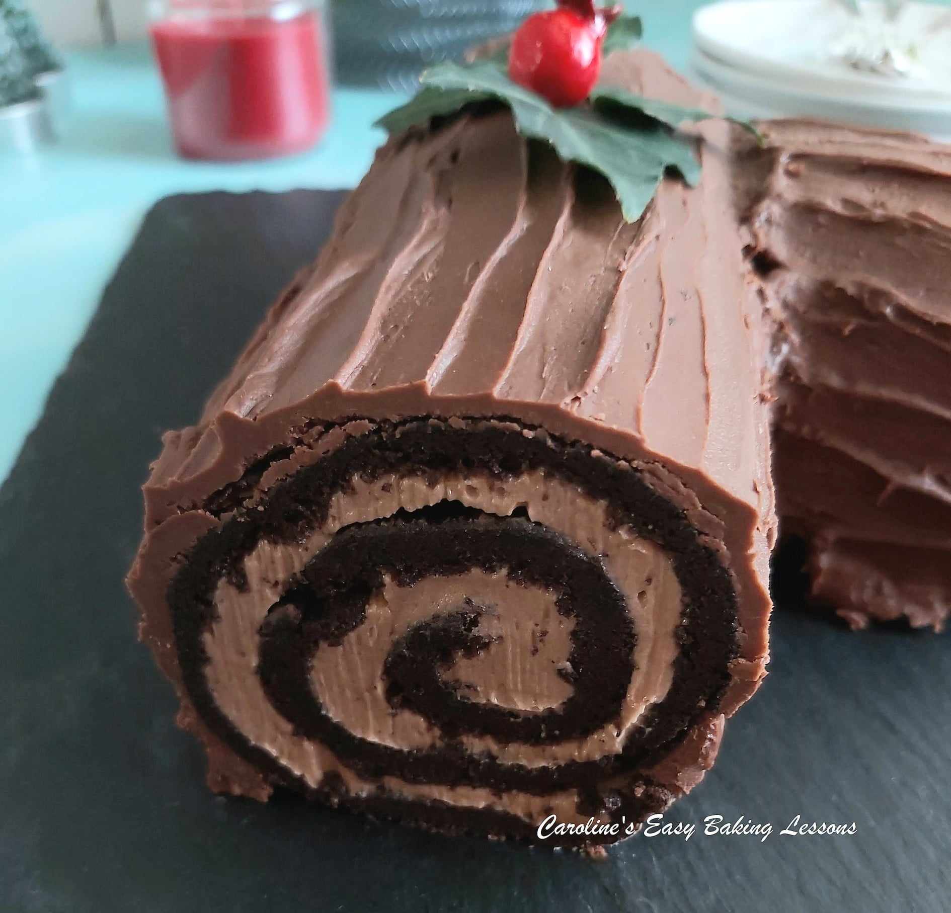 Close shot of the end of a double chocolate Swiss roll, Yule Log, with ganache on top as bark, showing the perfect swirl end.