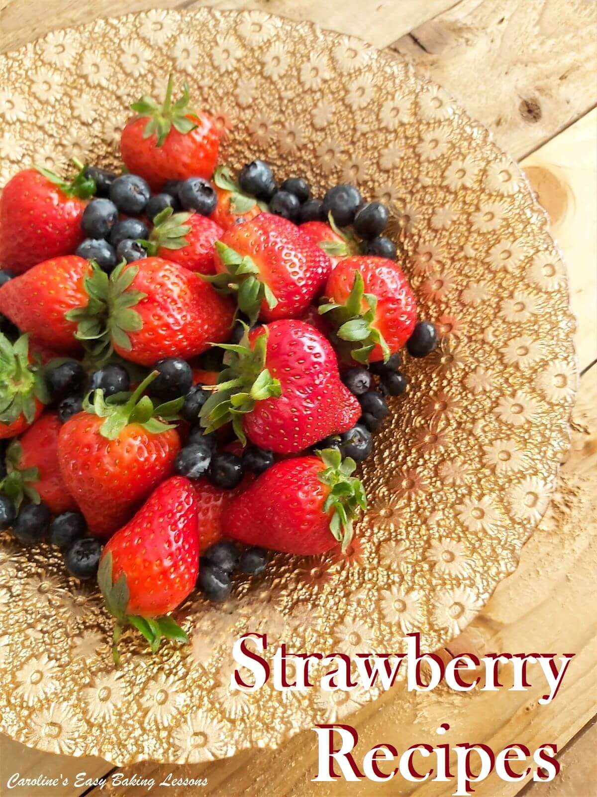 strawberries and blueberries in gold dish.