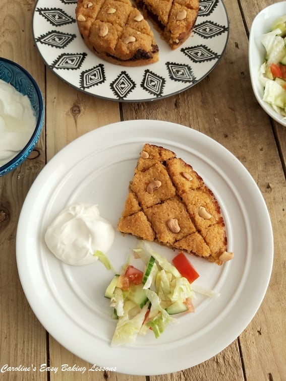 Overhead photo of table with plates and front one with slice of Bulgur pie with salad.