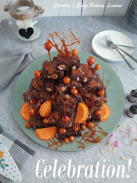Chocolate Orange Brownie Tower stack with fondant orange segments on a party table with places forks and party poppers.