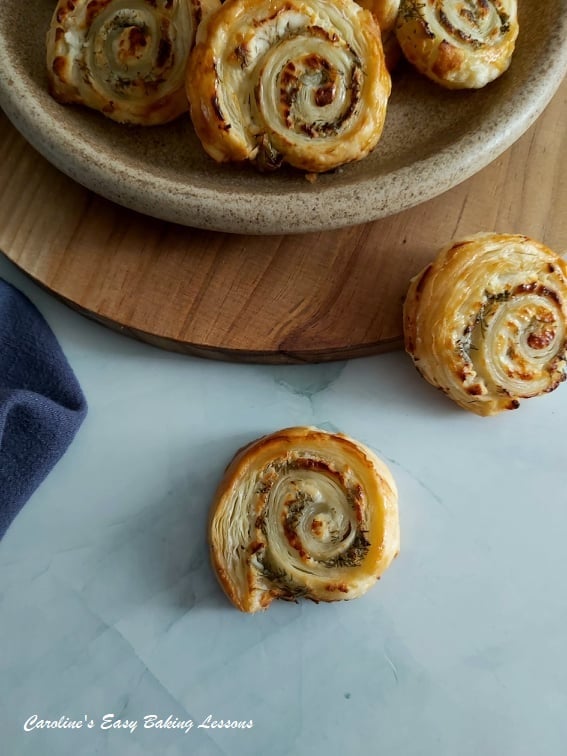 Quick Cheese Puff Pastry swi on a plate and on a blue backdrop.rls