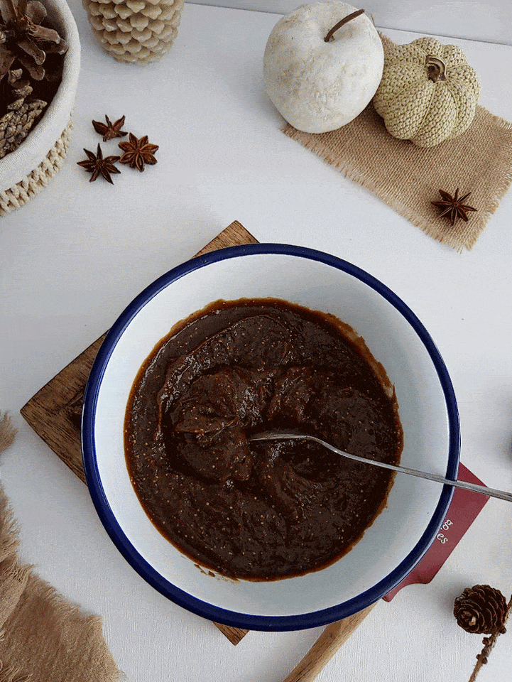 6 second gif of hand and spoon moving into bowl of thick set fig curd, showing thickness.