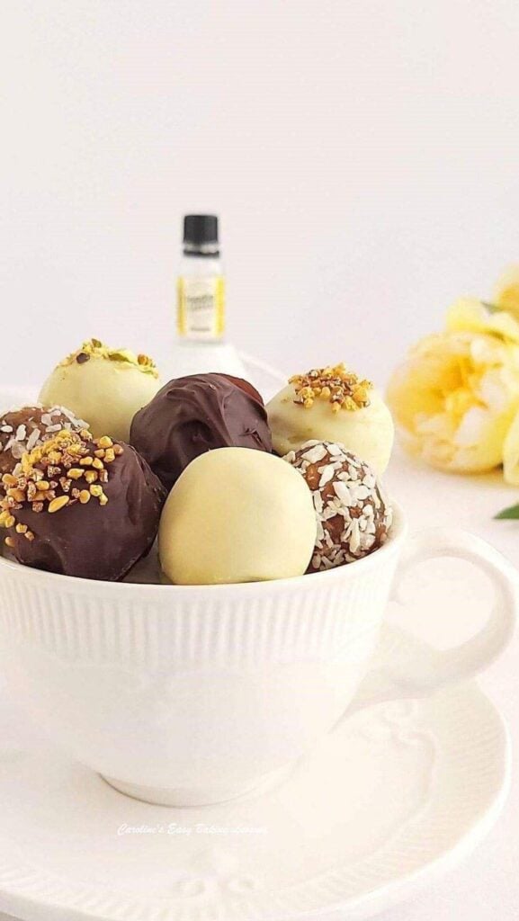 tall close shot of top of a white teacup of cake truffles.