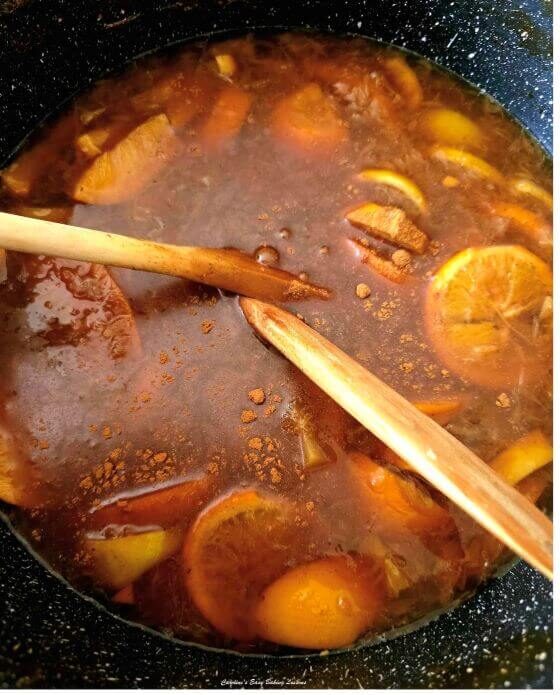 2 photo collage of adding spices to cooked citrus ice tea and in a glass over ic - photo 5.