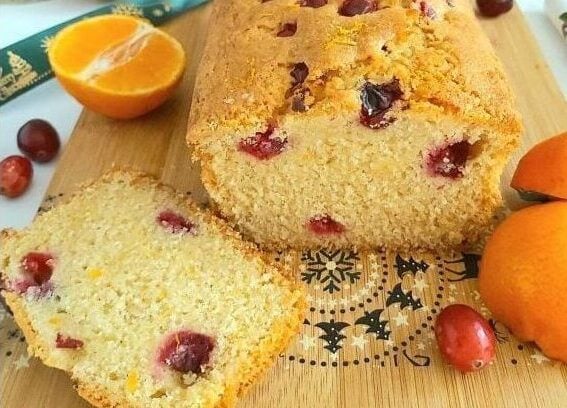Extra close front shot of a Madeira cake with orange and fresh cranberries inside and outside.