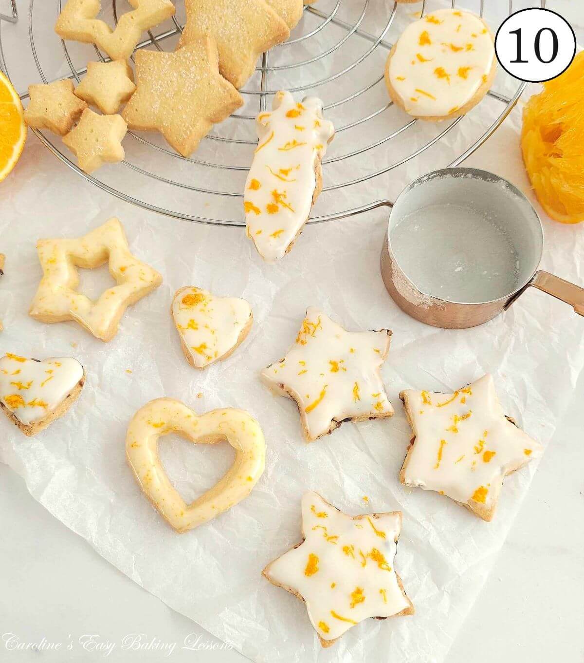Overhead close photo of seasonal shape Scottish shortbread with orange zest glaze, setting on cooling rack, with text 'photo 10'.