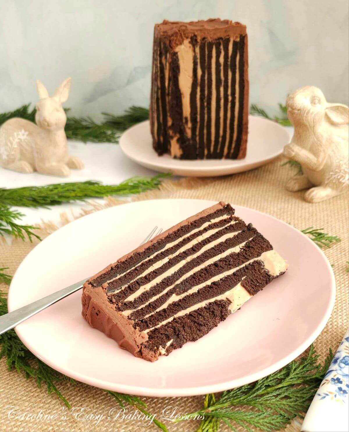 Slice of chocolate vertical Swiss roll cake showing showing 9 layers, with the cake to the background.
