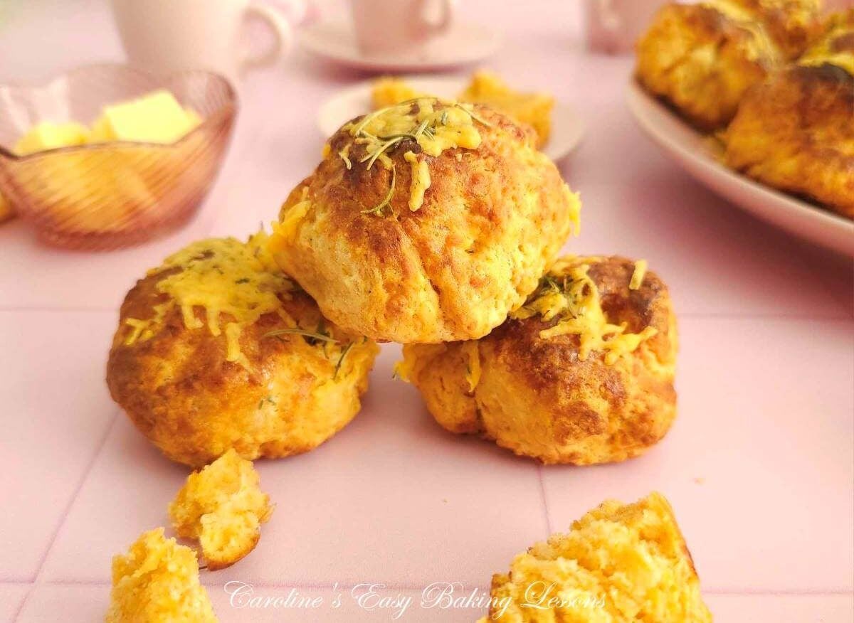 3 tear and share cheese scones stacked, 2 on bottom one on top, with pink table and crockery to the background.
