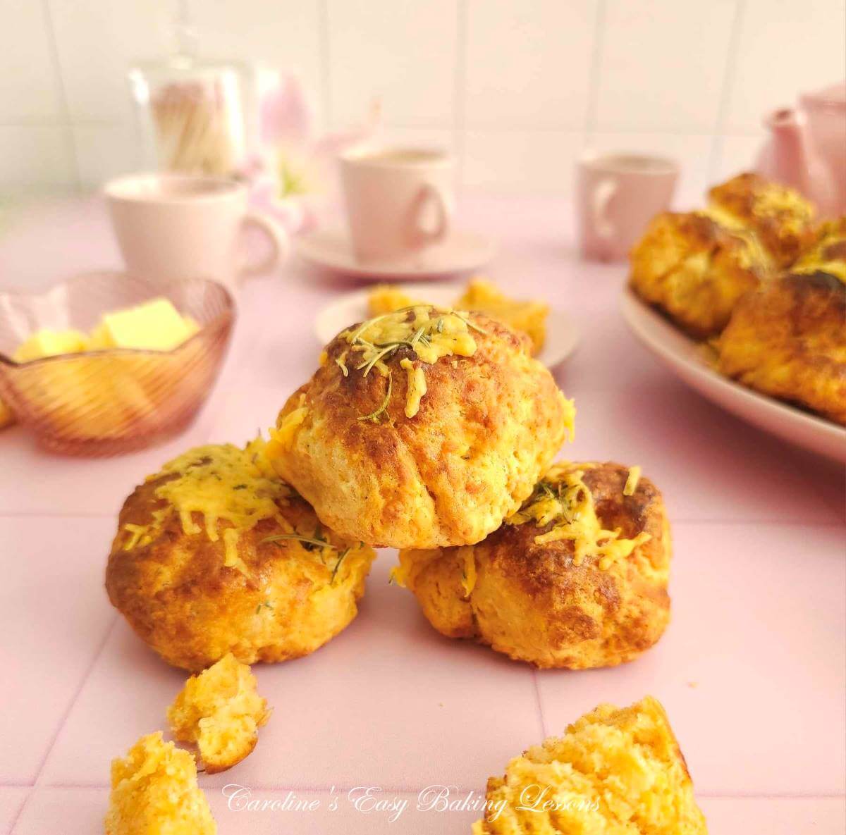 3 tear and share cheese scones stacked, 2 on bottom one on top, with pink table and crockery to the background.