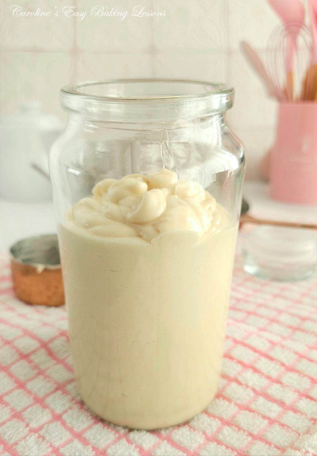 Close photo of a glass jar, no label but white paste inside & lid off.