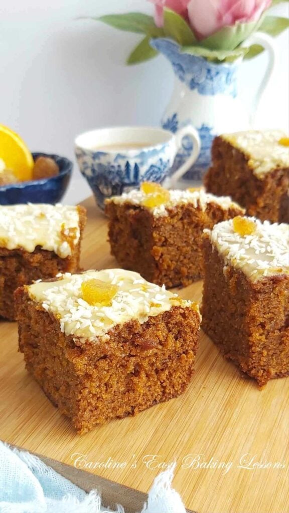 Photo of glazed gingerbread cake squares, with blue and white vintage crockery behind.
