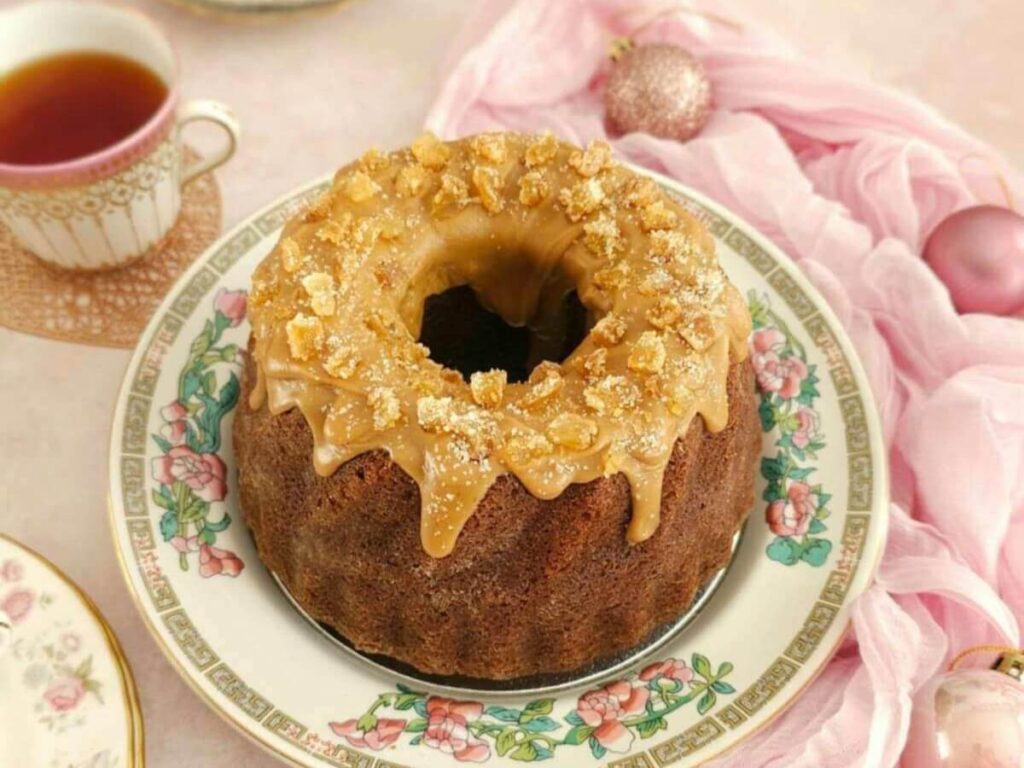 Overhead angled shot of pink Christmas table witha butterscotch glazed topped bundt cake.