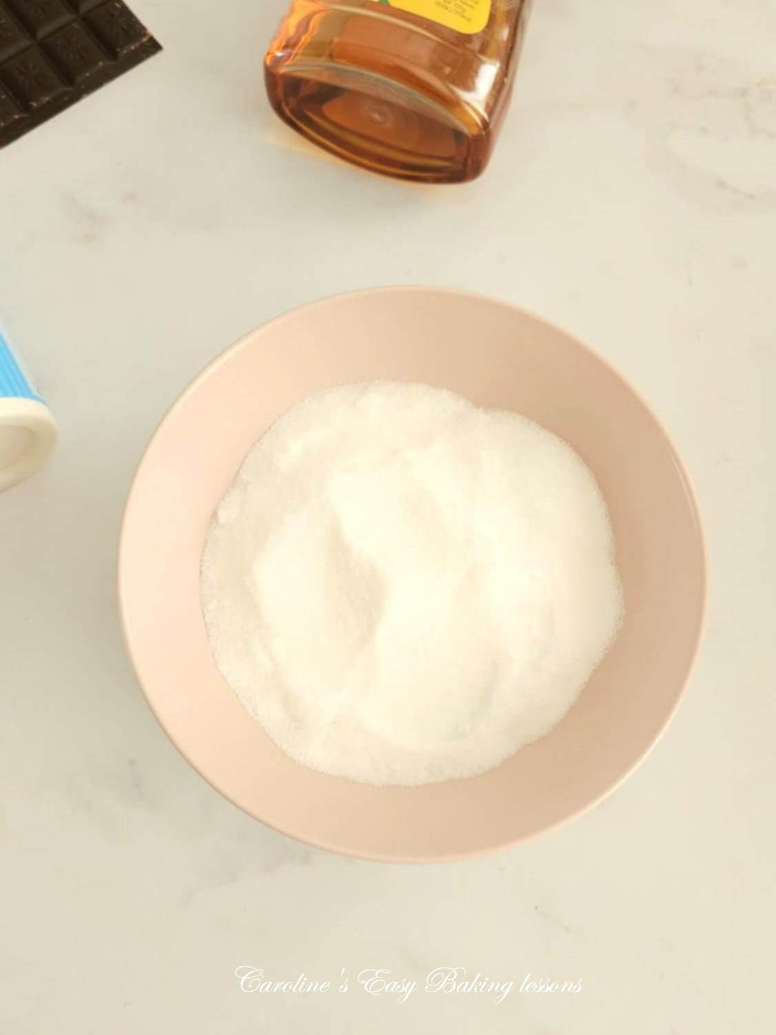 Photo of pink bowl of fine sugar called British Caster sugar.