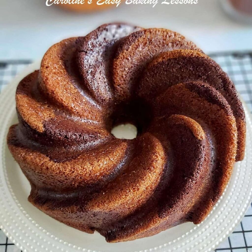 Extra close shot above a chocolate pumpkin patterned bundt cake cooling on rack.