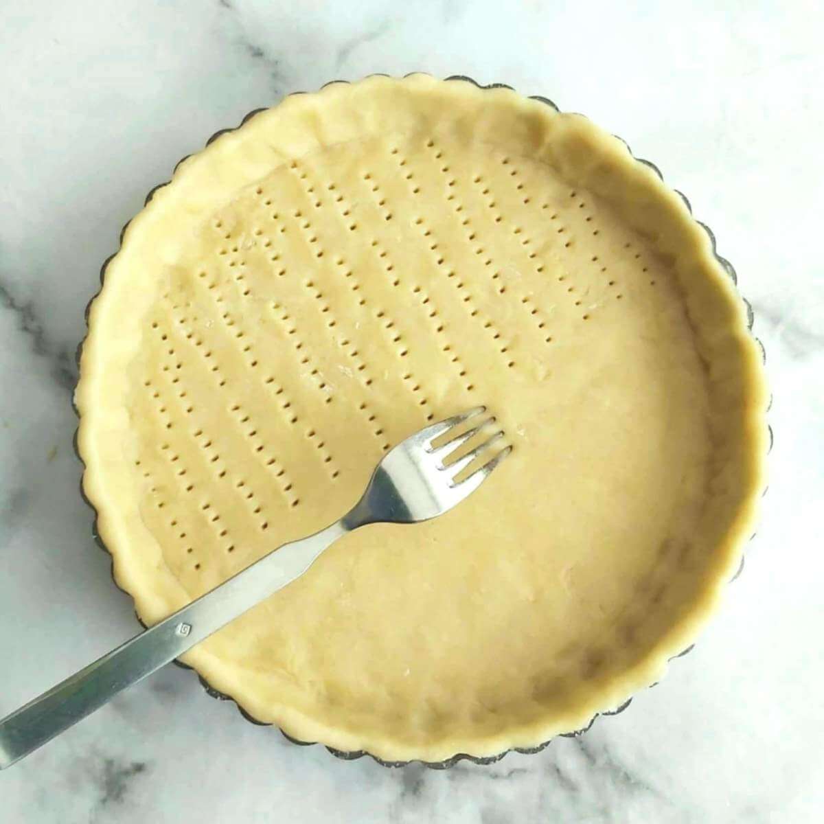 Clos eoverhead shot of using fork to 'dock' a unbaked pastry case.