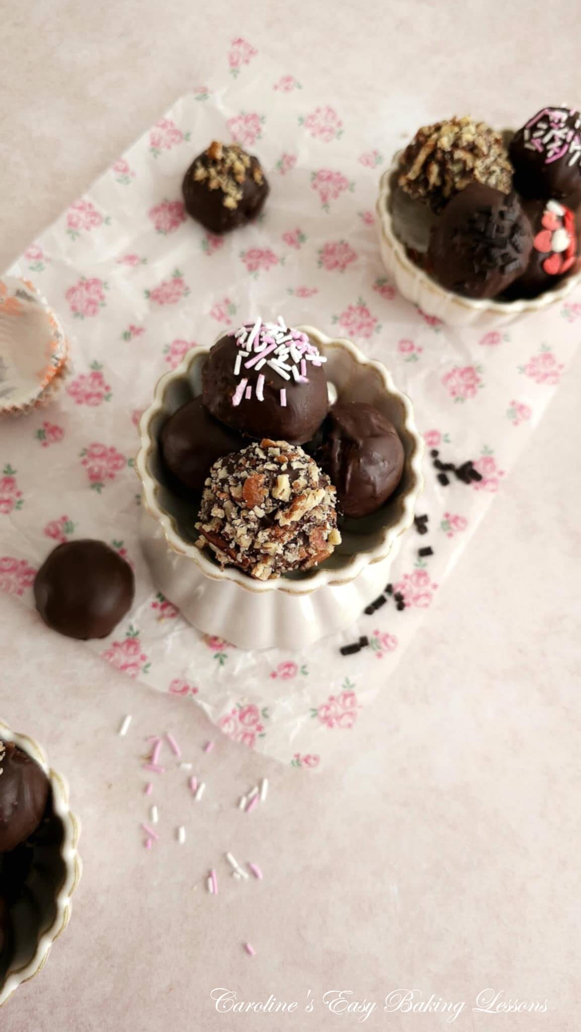 Overhead shot of 3 small ribbed bowls of chocolate coated almond truffles, some with sprinkles and chopped nuts.