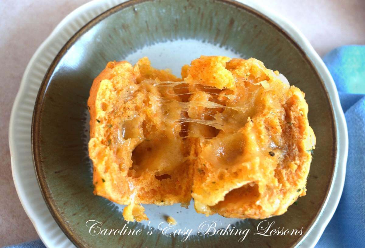 Extra close shot of plate with a halved cheese muffin, showing the mozzarella cheese pull stretch.