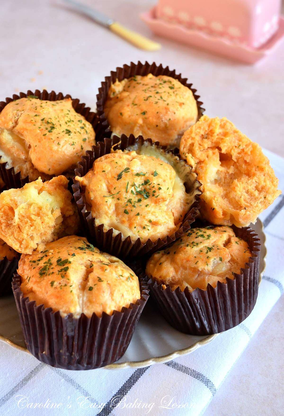 Close partial shot of plate of lots of stacked cheese & herb muffins.
