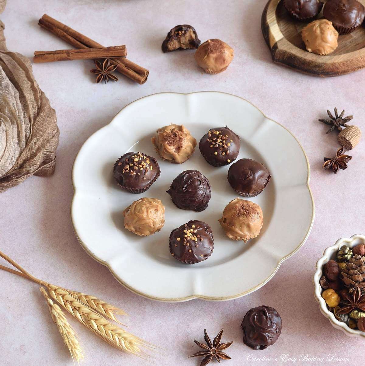 Angled c#shot of warm Autumn table with beige crockery, napkin, chai chocolate truffles in the centre, with anise, nutmeg and cinnamon in the background.