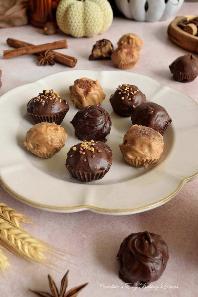 Close shot of chocolate and candy melt coated chai truffles with cinnamon, nutmeg and star anise spices to the sides.
