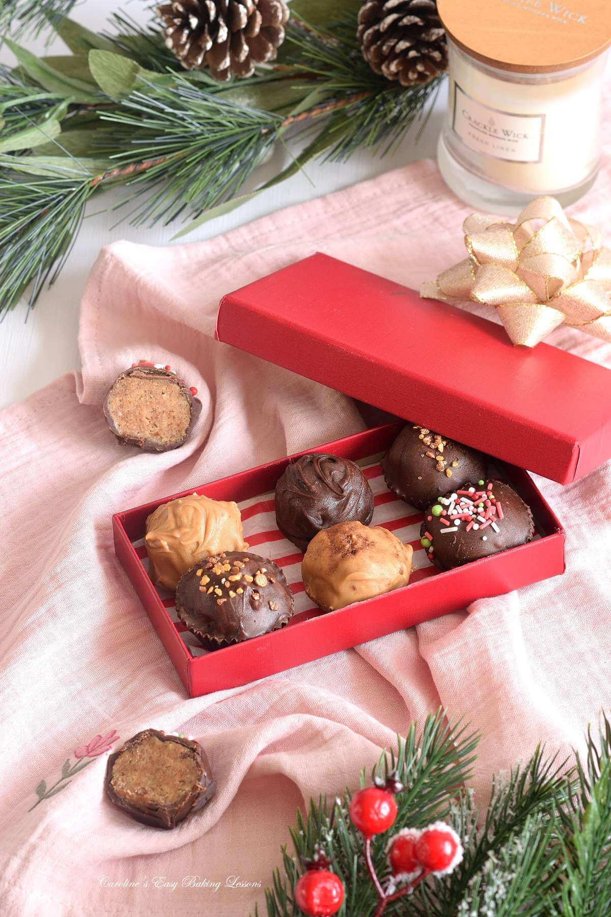 Christmas shop of red box of chai chocolate coated truffles with seasonal decorations to the sides.