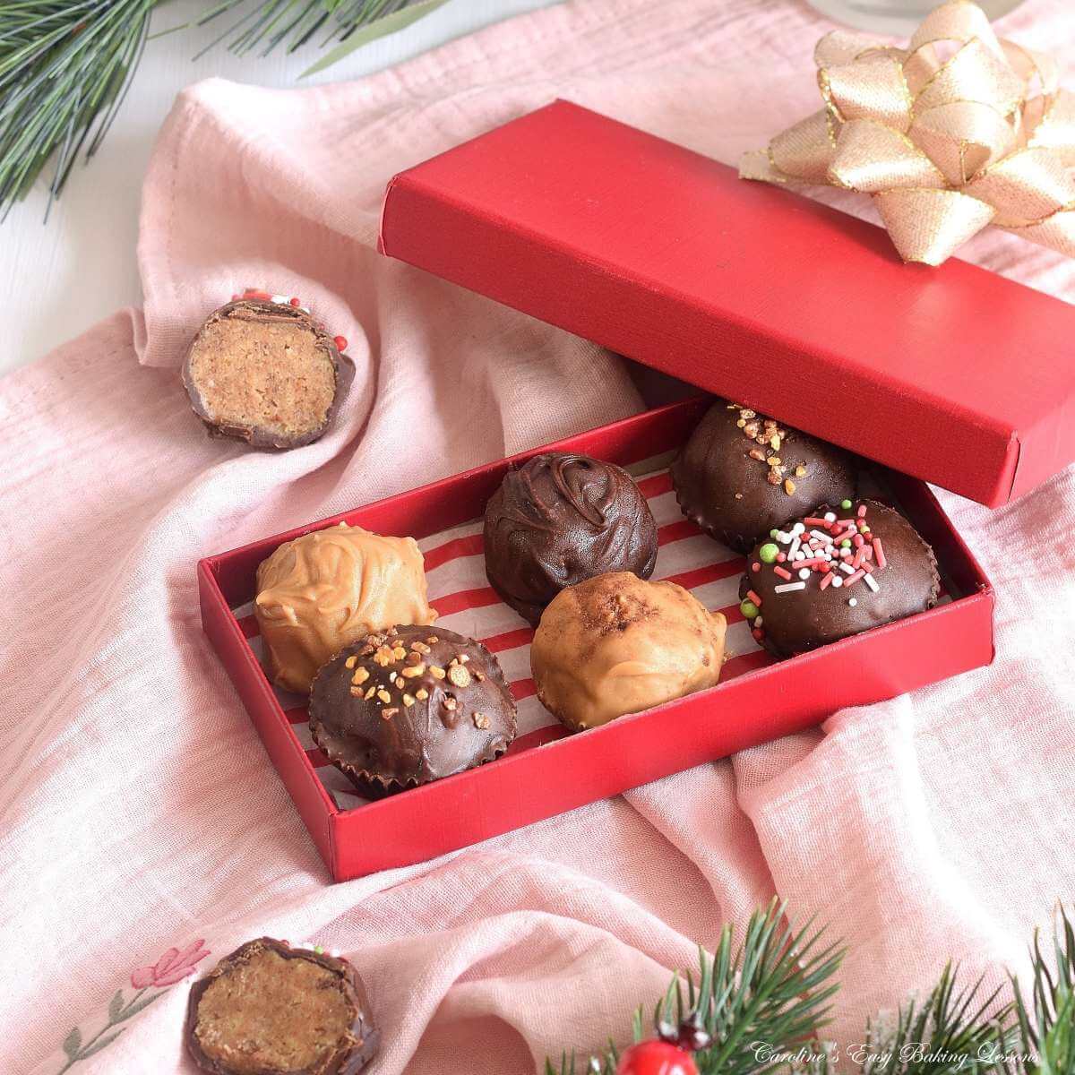 Overhead angles close shot of red box of homemade chai chocolate truffles, with Christmas decorations to the edges.