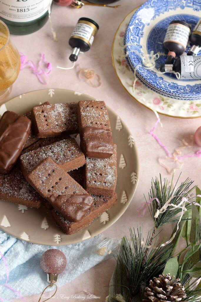 Overhead long shot of a New year's eve party with whisky, glasses, decorations, baubbles and heor plate of chocolate Scottish shortbread.