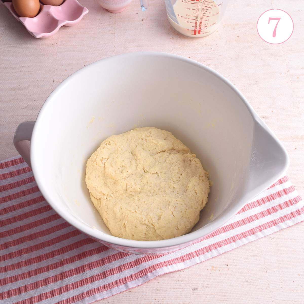 Image of pink and white mixing bowl with disc of scone dough, with text 'photo 7'.