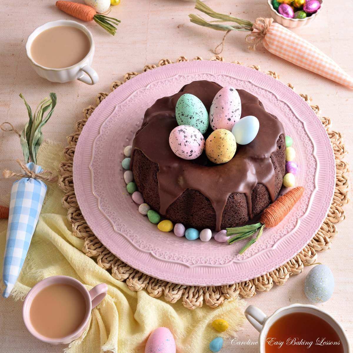 Image of a pastel and Spring coloured table with linen and crockery, and Easter decorations, with a Devil's Food chocolate bundt cake.