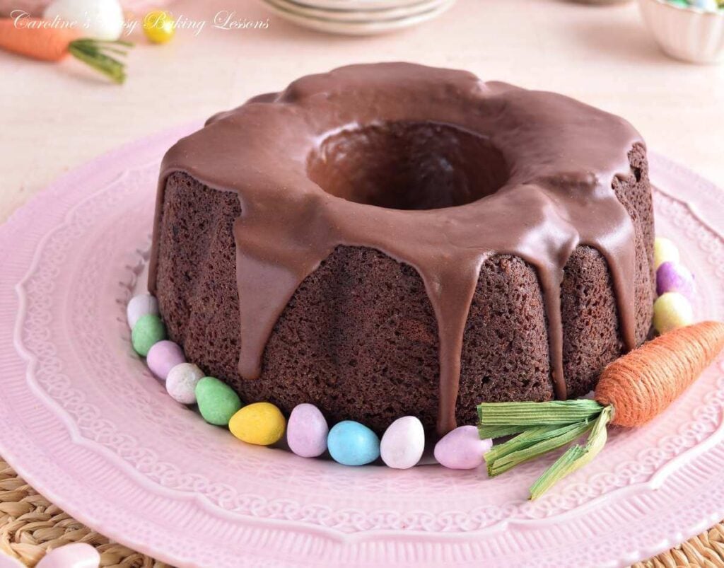 Horizontal, eye-level image of paste coloured Easter table with decorations and a Devil's Food bundt cake with mini eggs.