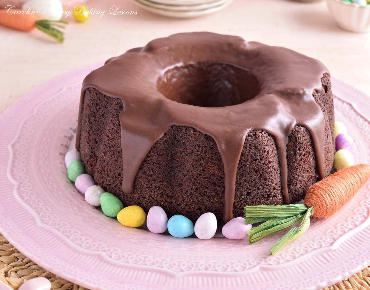 Horizontal, eye-level image of paste coloured Easter table with decorations and a Devil's Food bundt cake with mini eggs.