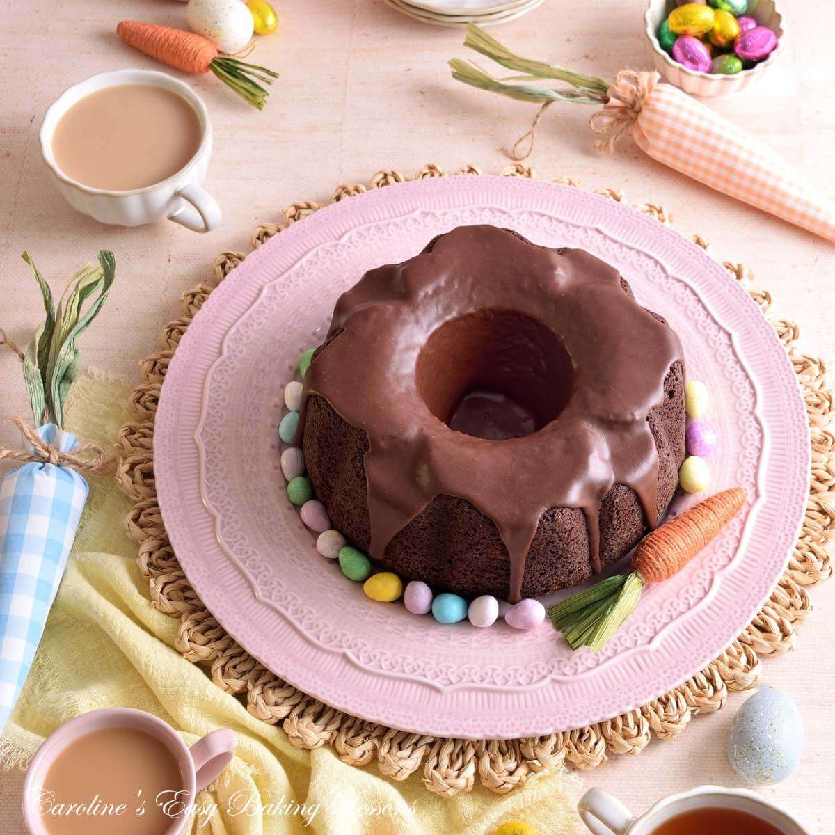 Overhead image of a pastel Easter table with decorations, and a flower shaped Devil's Food bundt cake in the centre.