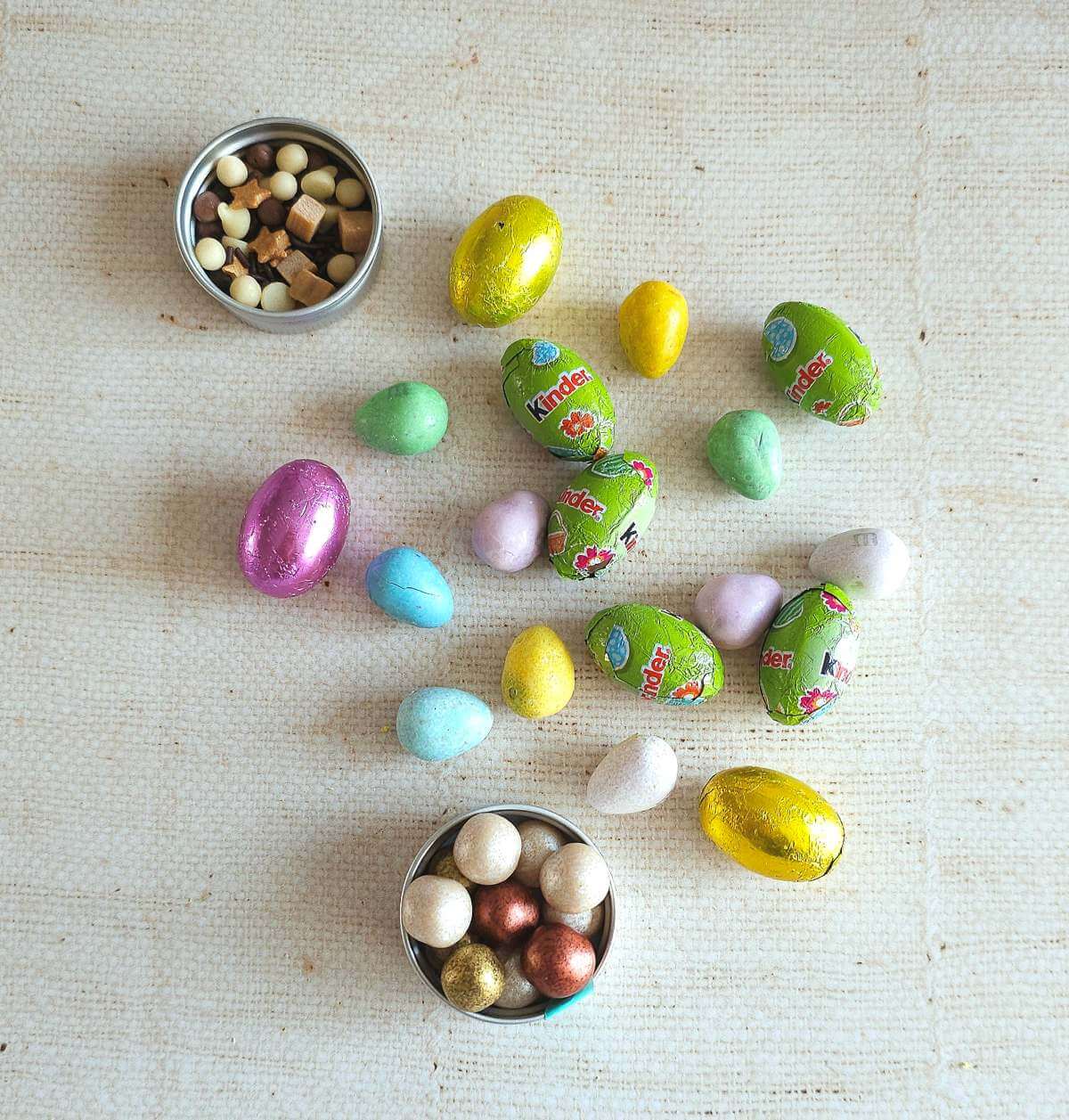 Overhead close shot of various chocolate mini eggs and some sprinkles.