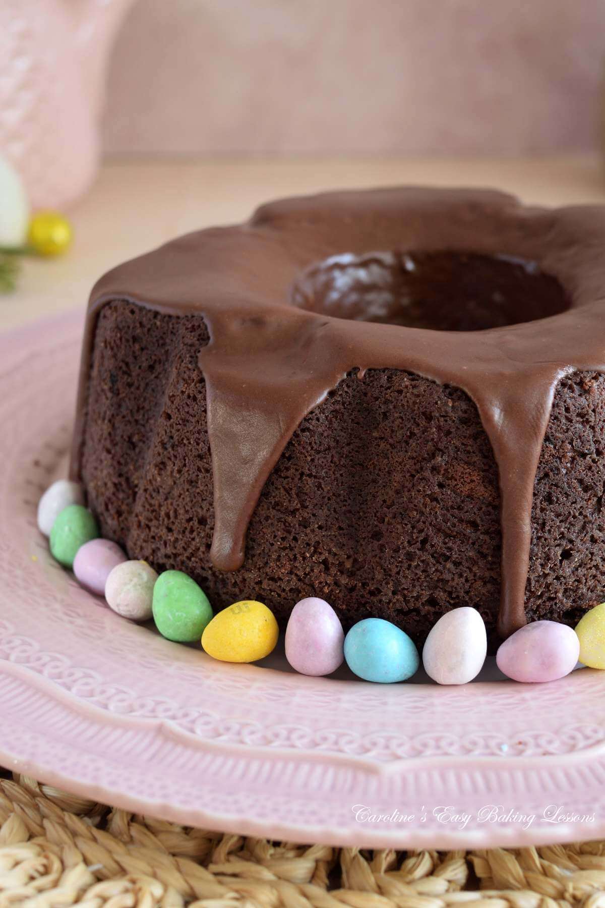 Close partial image of a Devil's food bundt cake, with mini chocolate eggs at th ebase.