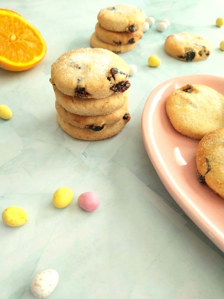 Pale blue table top with a stack of cranberry orange Mary Berry Easter Biscuits/cookies.