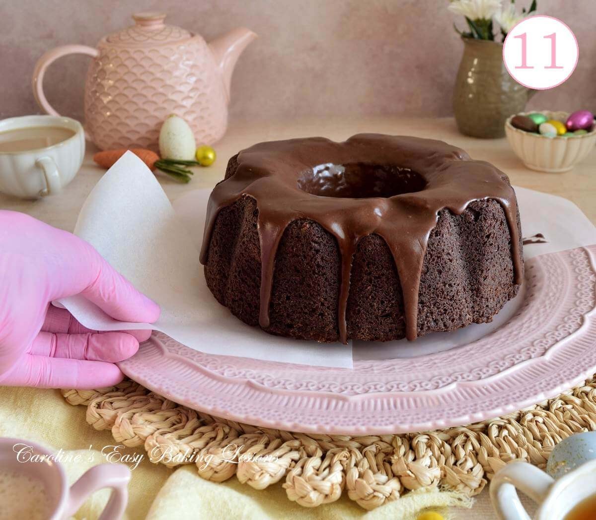 Image of a Devil's chocolate bundt cake and female hand removing paper from under cake with text 'photo 11'.