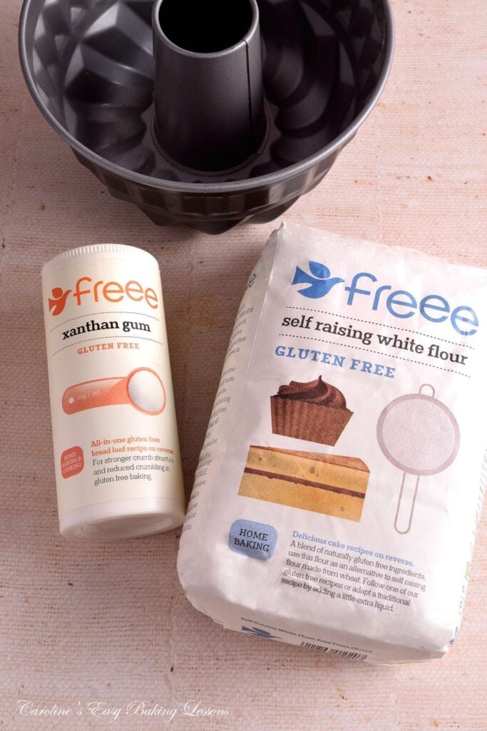 Close image of a bundt tin and a bag of Freee Foods (Doves farm), gluten-free self-raising flour and a tub of Freee Foods Xanthan gum.