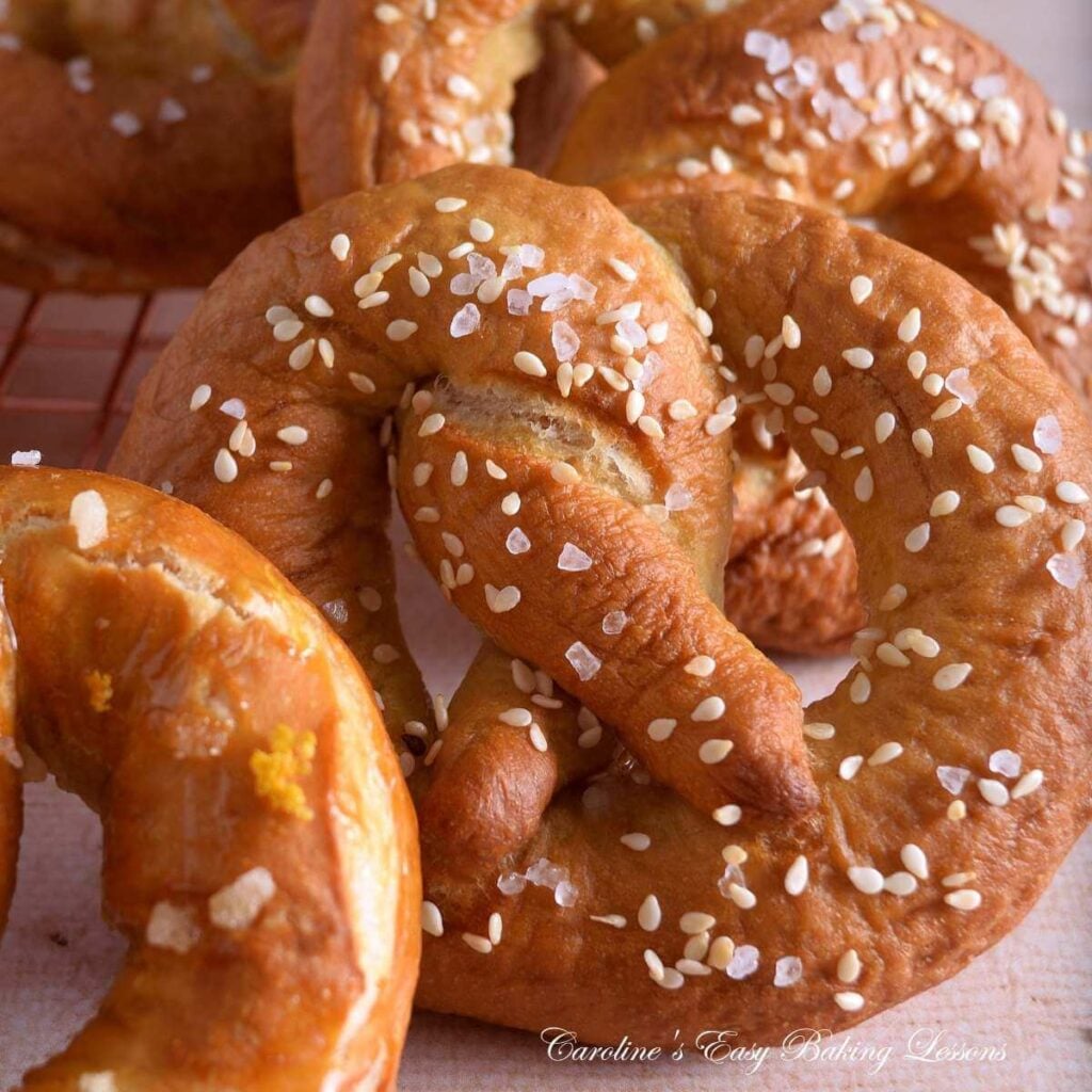 Extra close, partial shot of a golden, yeast pretzel,, with salt & sesame seeds.