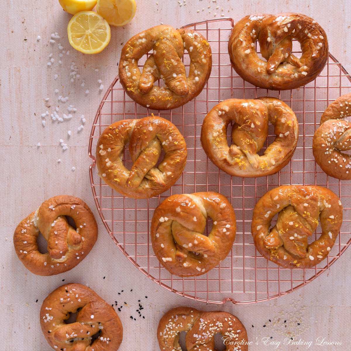 Overhead image on linen table, with rose gold round cooling rack, with homemade sweet and savoury pretzels, some onthe table and some seeds and salter scattered.