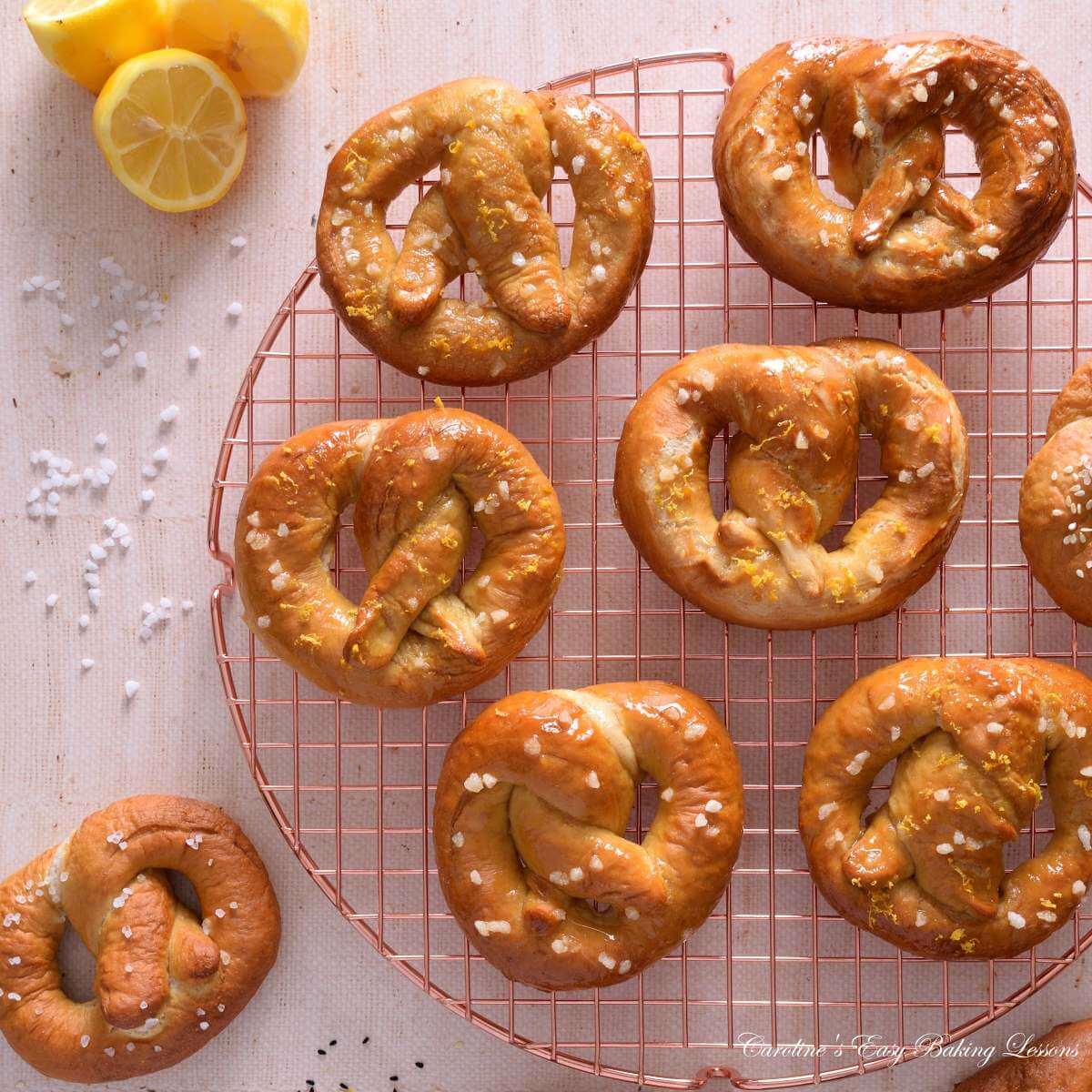 Flat lay image of homemade savoury and sweet yeast pretzels, on a round rose gold cooling rack.