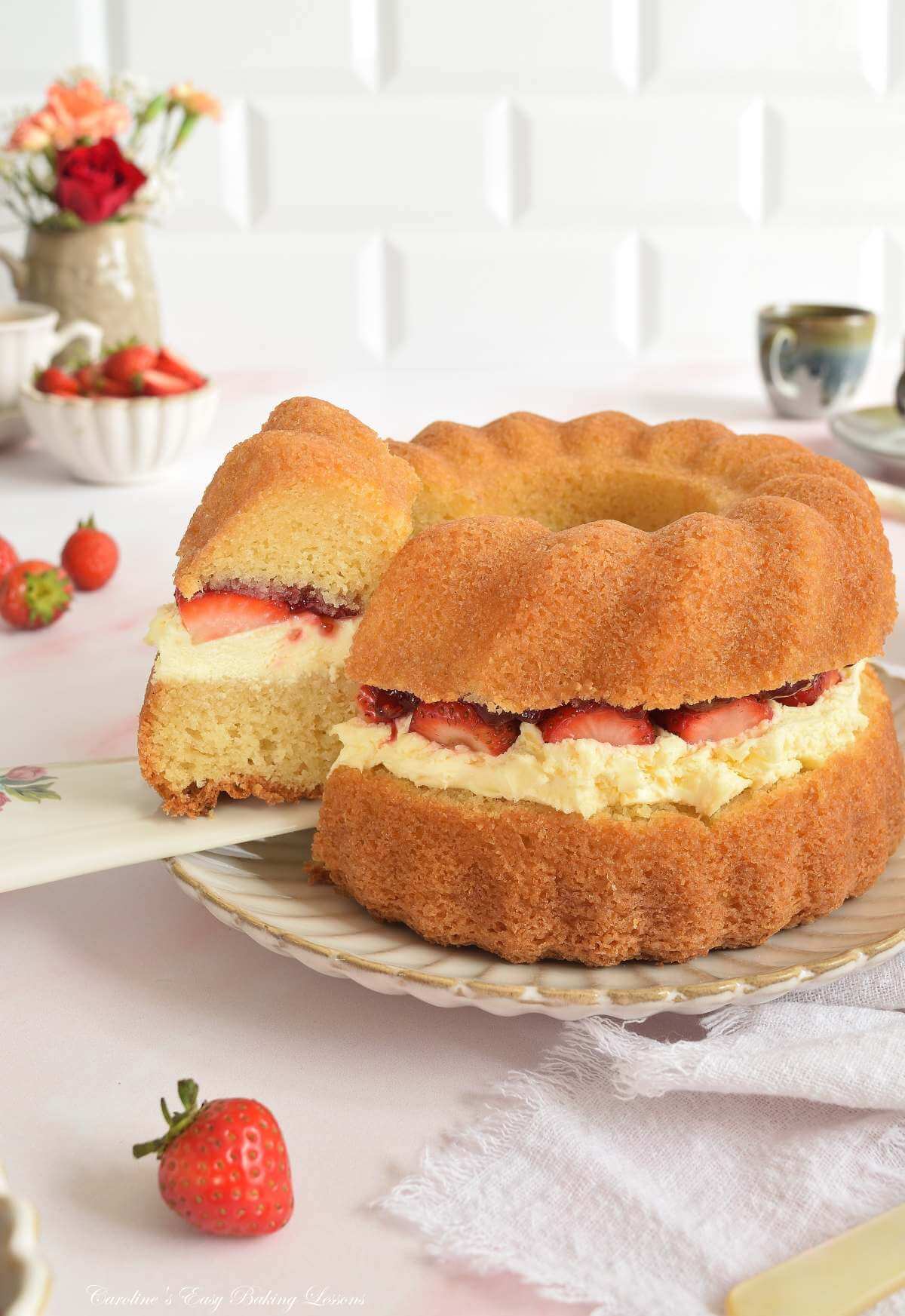 Vertical light airy image of a table with a layered bundt cake slice being removed.