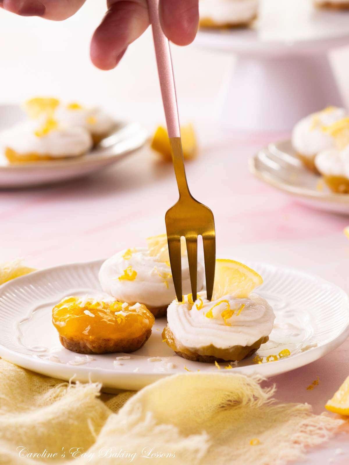 Extra close image of mini lemon coconut cream no-bake bites, with gold fork coming down from female hand above.