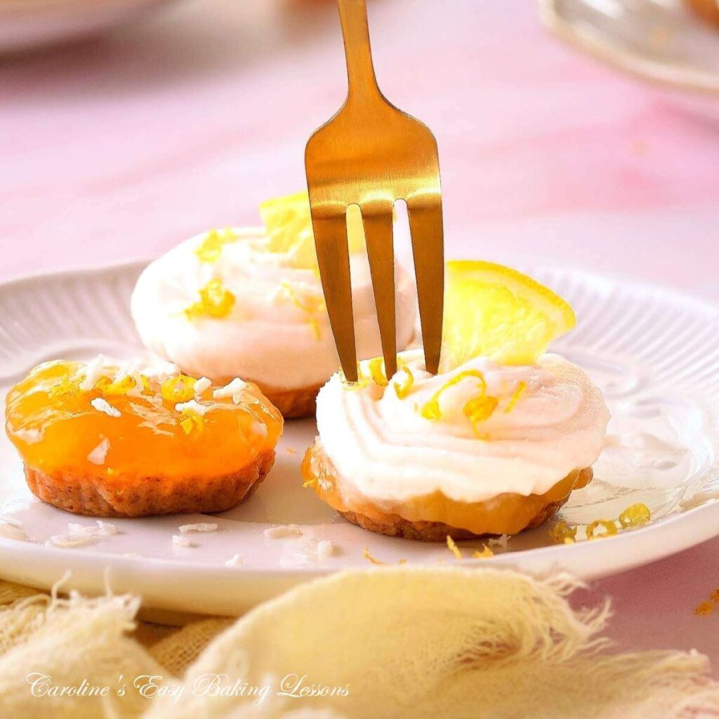 Close image of 3 mini no-bake lemon curd coconut cream bites, with gold fork above about to be eaten.
